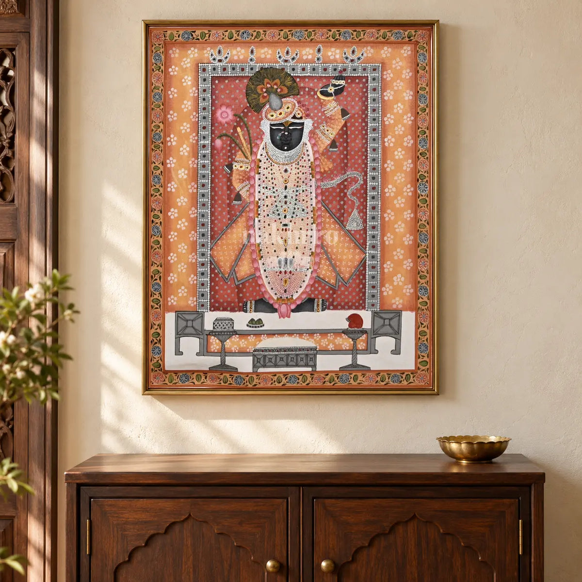 Shrinathji in Saffron and Rose — 18 × 24 inch original in a close cabinet setting, with Nakhrro watermark; styling visualisation