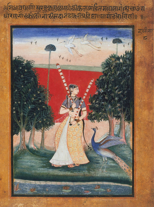 A woman in a pale flowing skirt raises her arms beside peacocks and dark water, with trees and a red terrace beyond.
