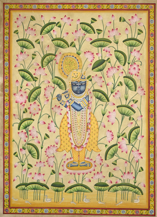 Krishna playing the flute among pink lotuses and green leaves on a pale golden background, framed by a painted floral border.