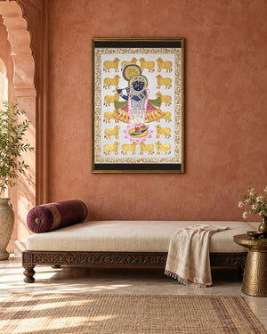 Krishna with Golden Cows and a Floral Border, framed above a daybed in a contemporary haveli; styling mockup, 2 by 3 feet