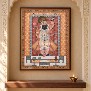 Shrinathji in Saffron and Rose — 18 × 24 inch original in a close niche setting, with Nakhrro watermark; styling visualisation