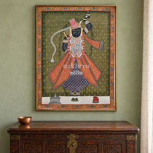 Shrinathji in Rose Robes on Olive — 18 × 24 inch original in a close collector setting, with Nakhrro watermark; styling visualisation